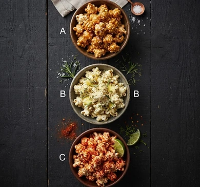 Three bowls of differently flavored popcorn labeled A, B, and C on a dark wooden surface, appearing to be a sample product comparison pin.